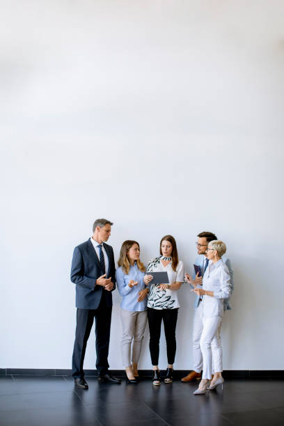 istock Business people standing by the wall in the office 1358416761