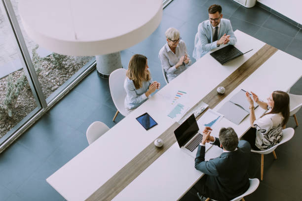 Aerial view at group of business people working together and preparing new project on a meeting in office Aerial view at group of business people working together and preparing new project on a meeting in the office business caucasian meeting men stock pictures, royalty-free photos & images