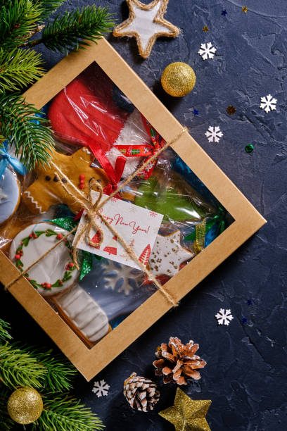 istock Christmas gift with gingerbread on blue background with fir branches, bumps and decor 1358417824
