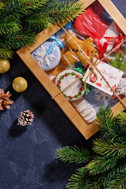 istock Christmas gift with gingerbread on blue background with fir branches, bumps and decor 1358417827