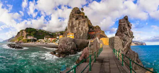 Photo of Madeira island vacation - picturesque village Ponta do Sol with impressive rocks, nice beach and colorful houses. Portugal