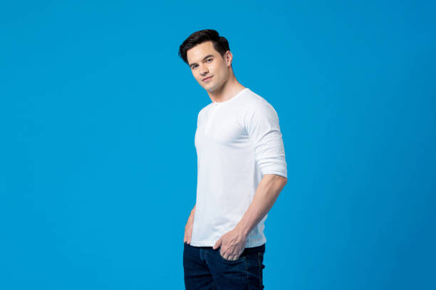 istock Smiling young handsome Caucasian man in plain white t-shirt looking at camera on isolated blue background 1358427486