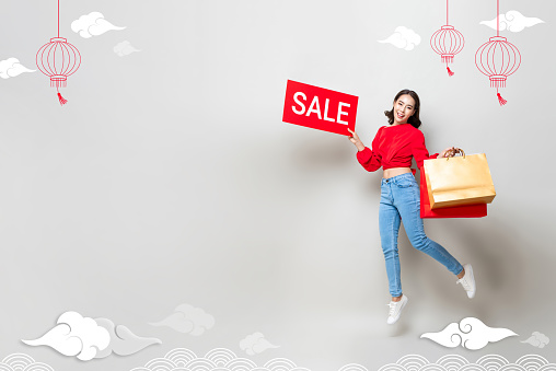Lunar new year shopping season background with Asian woman holding bags and red sale sign