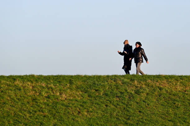 Two people jogging through lush green landscape, promoting intergenerational physical activity, motivation, and shared commitment to personal health.
