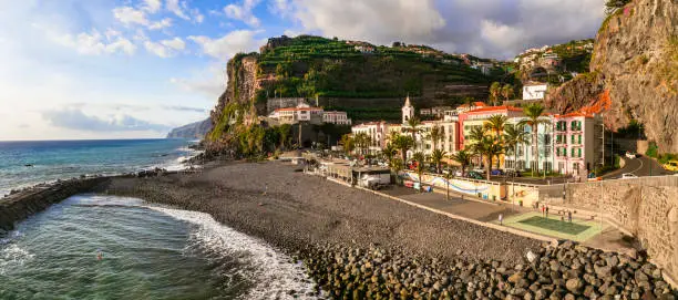 Photo of Madeira island vacation - picturesque village Ponta do Sol with impressive rocks, nice beach and colorful houses. Portugal