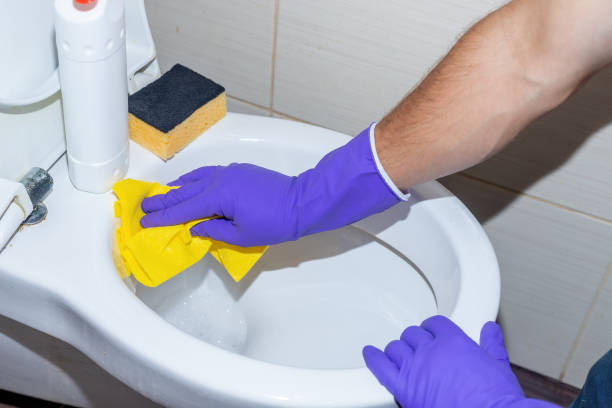 istock Housekeeper with Protective Gloves in Hands Cleaning Bathroom 1358433382