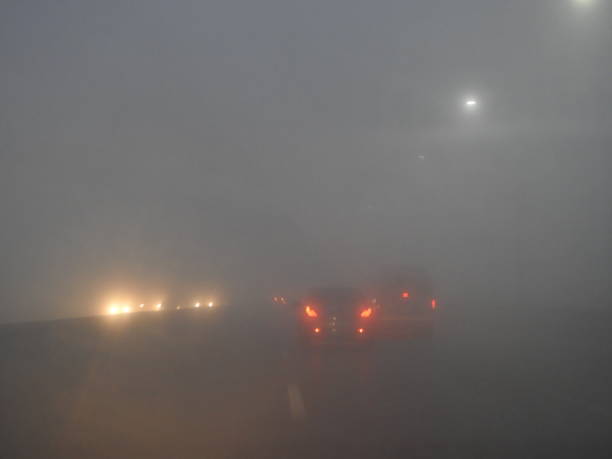 高速道路の朝早く霧と霧が重いため、道路上の非常にぼやけた視界が悪い - street light fog morning country road ストックフォトと画像