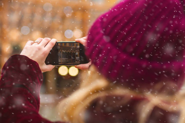 istock Young lady taking photo at the winter fair 1358438409
