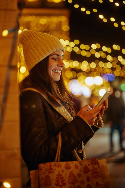 istock Woman on Christmas time using the phone 1358439576