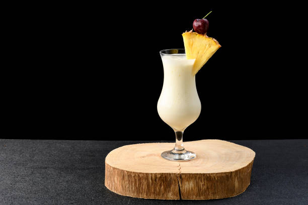 istock two glasses with pina colada cocktail, a whole pineapple next to the drinks, isolated on black background 1358439893