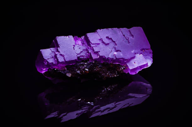 modern dark background, macro close-up of semi-precious gemstone isolated black background mirror reflection.