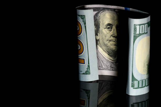 istock One Hundred Dollar Bill, US, on Black Background with Benjamin Franklin, Copy space on Left 1358445956