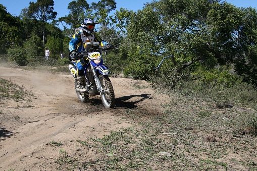 An Enduro bike racer riding on a dirt motocross road