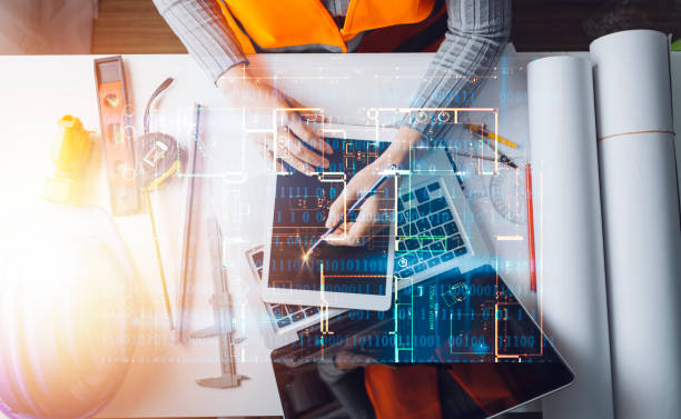 istock Construction engineer working at blueprint to build large commercial buildings in office. Engineering tools and construction concept. 1358446254