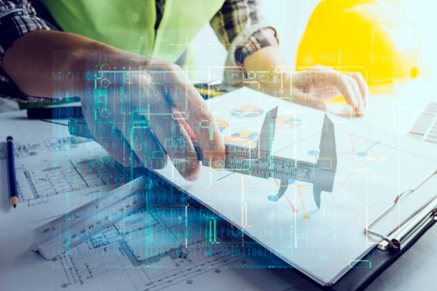 istock engineer working at a drawings of house in office for discussing. Engineering tools and construction concept. 1358446367