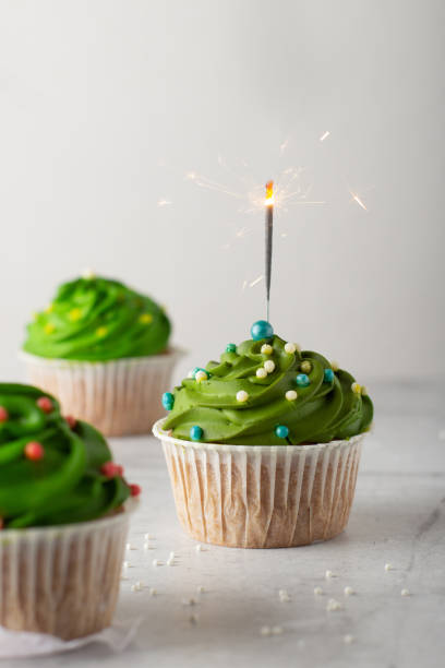istock christmas cupcakes with green cream and sparklers 1358446475