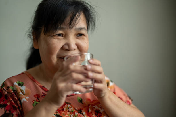 istock Senior asian woman drinking water 1358449097
