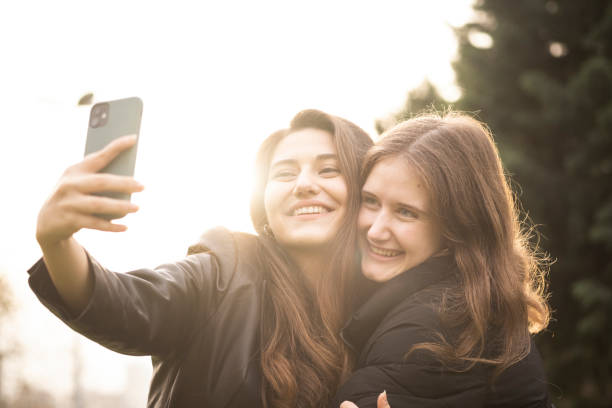 istock Two beautiful girls taking selfies 1358451516