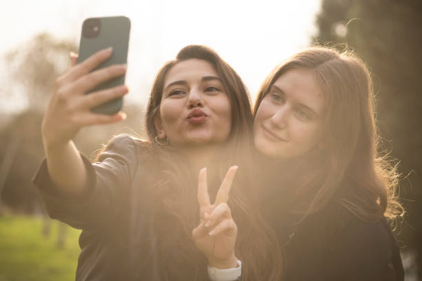 istock Two beautiful girls taking selfies 1358454163