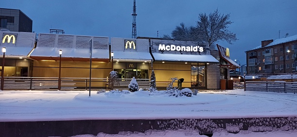 Chernihiv - Ukraine. 31 January 2021: \nSignboard for McDonald's family restaurant outside. McDonald's building during snowy winter. Sign of McDonald's in Chernihiv