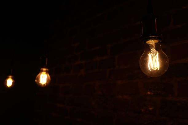 istock Decorative antique edison style light bulbs against brick wall background. Switched on bulbs 1358460832