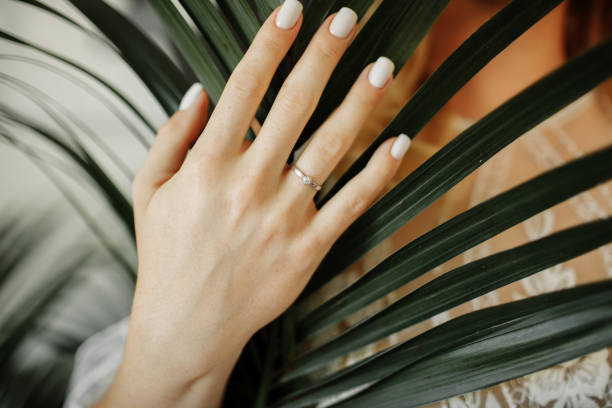 istock white gold ring with diamond on bride hand on the palm leaf background. wedding day 1358460839