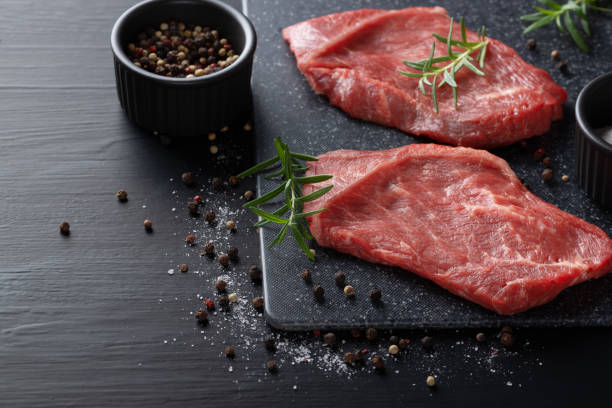 istock Fresh meat with ingredients for cooking on dark table 1358462208