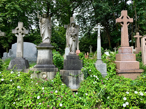 LONDON, ENGLAND. Old graves in the East cemetery of Highgate Cemetery. Selective focus. Vertical