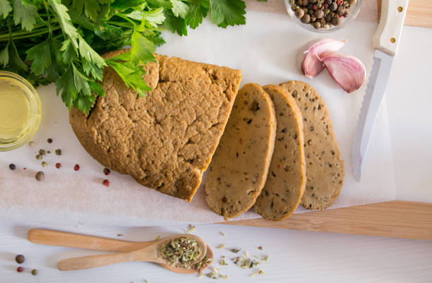 Seitan or vegan meat sliced with spices. Top view Seitan or vegan meat sliced with spices such as oregano, pepper, garlic, and parsley. Top view meat substitute stock pictures, royalty-free photos & images