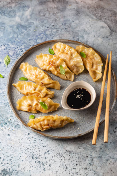 istock Asian dumplings with soy sauce 1358463100