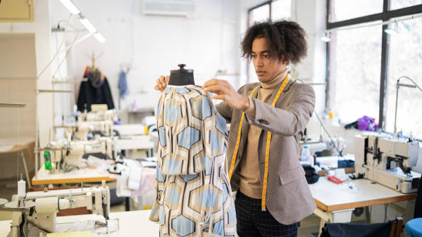 African american male tailor   at work in his workshop, measuring handcrafted production of fashion clothes, concept of diversity and integration, new small social business african american male tailor   at work in his workshop, measuring handcrafted dress, concept of diversity and integration, new small social business fashion designer stock pictures, royalty-free photos & images