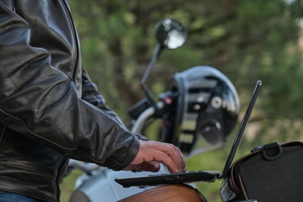 istock Side view of an unrecognizable man using a laptop while traveling with his motorcycle. 1358468343