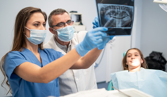Retrato de un dentista sosteniendo una imagen de rayos X photo