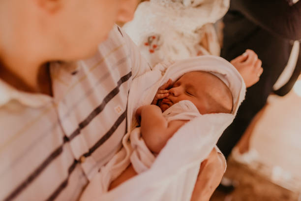 baby hand in arms of godfather rite of sacrament of epiphany baby hand in arms of godfather. rite of sacrament of epiphany in church pics of the godmother stock pictures, royalty-free photos & images