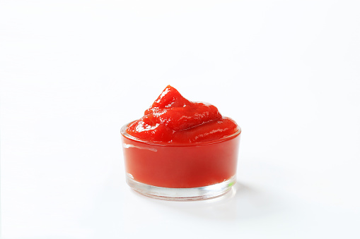 Swirl of tomato ketchup in a small glass dish
