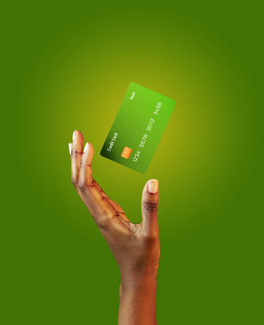 African american female hand and levitating template mockup Bank credit card with online service on green background. High quality photo