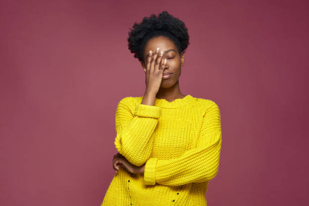Upset african american young girl with facepalm gesture, blaming herself, feeling sorrow because of bad memory Upset african american young girl with facepalm gesture, blaming herself, feeling sorrow because of bad memory. High quality photo head in hands stock pictures, royalty-free photos & images