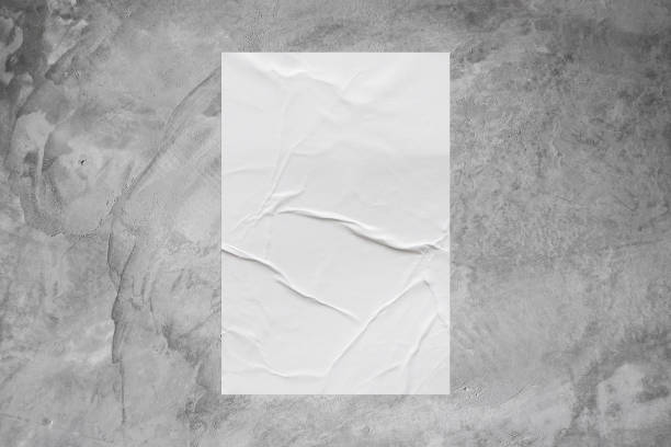 istock Blank white wheatpaste glued paper poster mockup on concrete wall background 1358491931