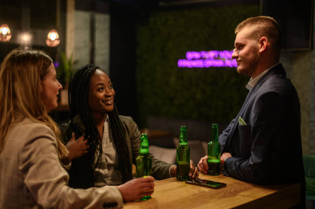 istock Cheerful colleagues drinking beer in the bar together after work 1358492520