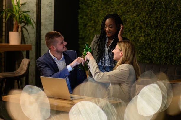 istock Colleagues working on a laptop and having a meeting in a cafe while toasting 1358492526