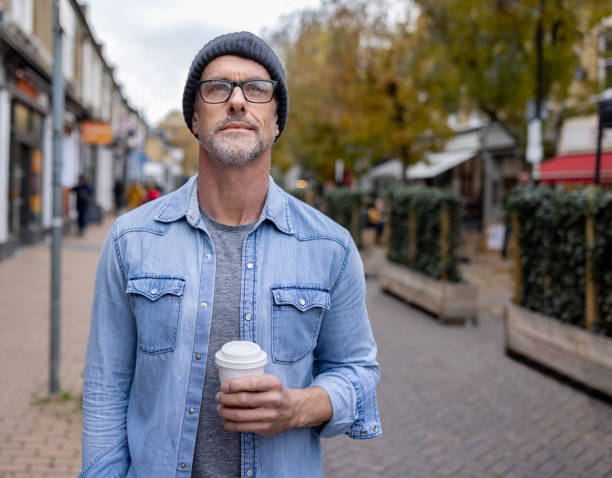 Thoughtful man out on the streets drinking a cup of coffee