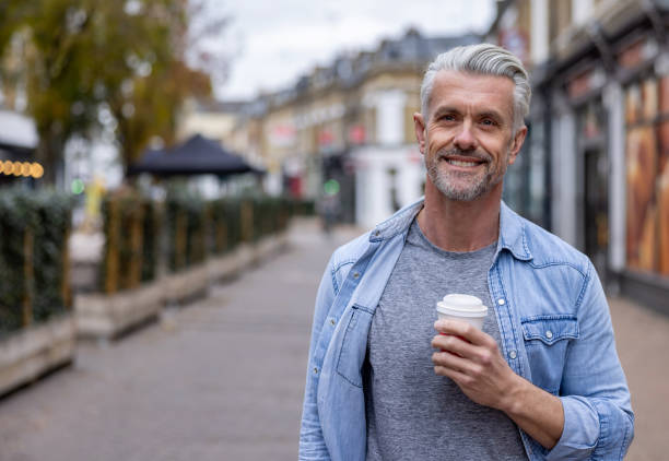 istock Happy man outdoors drinking a cup of coffee on the go 1358492875