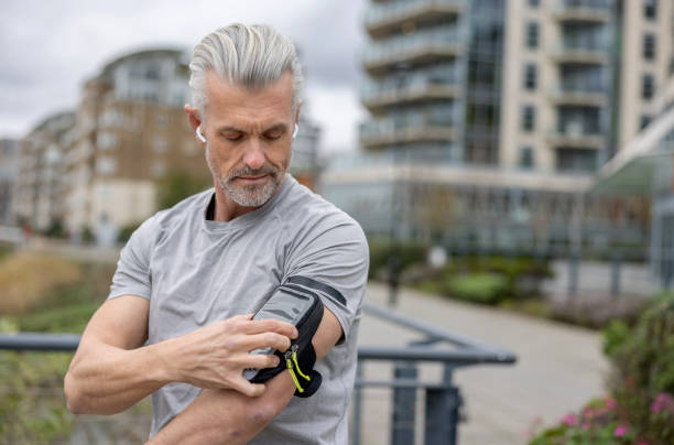 istock Male runner using an arm band for his cell phone while running outdoors 1358492910