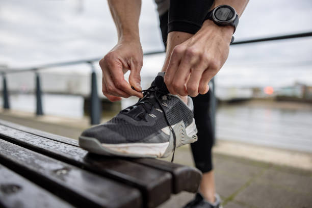 istock Close-up on a male runner tying his shoelace before going for a run 1358492919