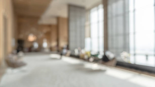 istock Blurred hotel or office building lobby blur background interior view toward reception hall, modern luxury white room space with blurry corridor and building glass wall window 1358493505