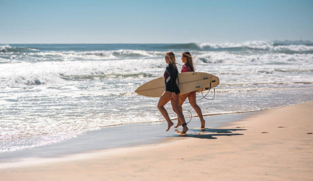 istock Young Female Surfers with Boards on Tallebudgera Beach 1358493689