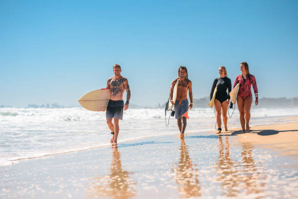 istock Gold Coast Surfers Walking with Boards at Water’s Edge 1358493694