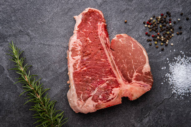 Large Porterhouse Steak with herbs and spices Raw Porterhouse Steak with Rosemary, Cracked Pepper and Kosher Salt porterhouse steak stock pictures, royalty-free photos & images