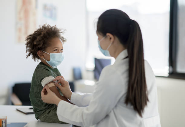 getting a bandage after a vaccine - masker stockfoto's en -beelden