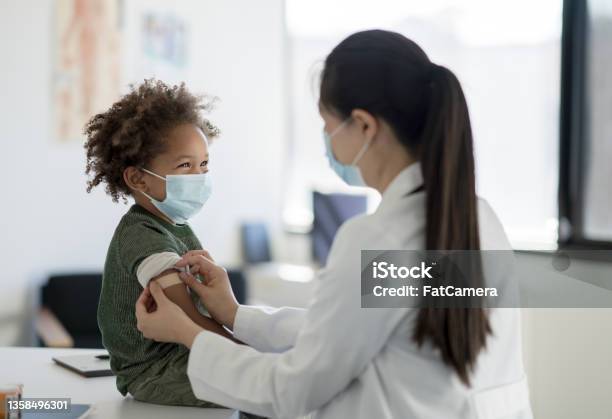 Getting A Bandage After A Vaccine Stock Photo - Download Image Now - Child, Vaccination, Doctor